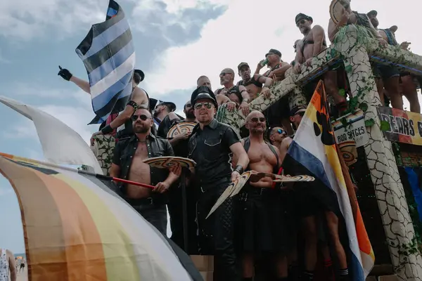 Sitges, İspanya - 8 Haziran 2025: Kalın kostümlü katılımcılar Sitges Onur Yürüyüşü sırasında renkli bir şamandırada dans edip tezahürat yapıyorlar. Festival sahnesi özgürlüğü, çeşitliliği ve LGBTQ + gururu kutluyor.