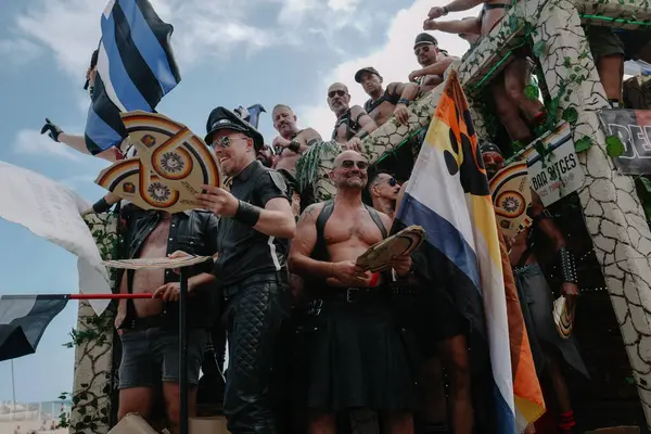 Sitges, İspanya - 8 Haziran 2025: Kalın kostümlü katılımcılar Sitges Onur Yürüyüşü sırasında renkli bir şamandırada dans edip tezahürat yapıyorlar. Festival sahnesi özgürlüğü, çeşitliliği ve LGBTQ + gururu kutluyor.