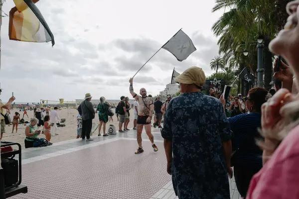 Sitges, İspanya - 8 Haziran 2025: İnsanlar Sitges Onur Yürüyüşü sırasında gökkuşağı bayrakları sallayarak renkli kıyafetler içinde sevinçle yürüyorlar. Kalabalık deniz kenarında aşkı, çeşitliliği ve LGBTQ + gururunu kutluyor.