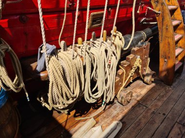 Many different ropes on an old wooden sailing ship are needed for the crew to travel the seas and oceans.