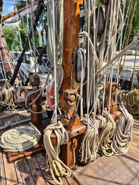 Many different ropes on an old wooden sailing ship are needed for the crew to travel the seas and oceans.