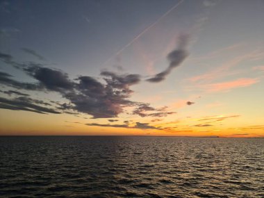 Güneş ufukta, sakin denizin arka planında batıyor..