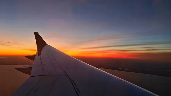 Skrzydło Samolotu Lądującego Lotnisku Tle Szkarłatnego Zachodu Słońca — Zdjęcie stockowe