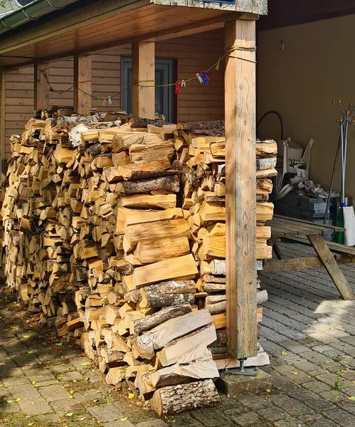 積み重ねられた切り取られた木は冬のための村のストーブのために準備されます — ストック写真