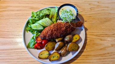 Hamurda kızarmış balık, patates ve öğle yemeği için taze salata..