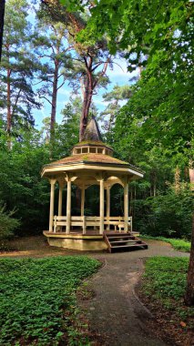 İnsanlar ağaçların arasında dinlensin diye küçük yuvarlak ahşap bir çardak..