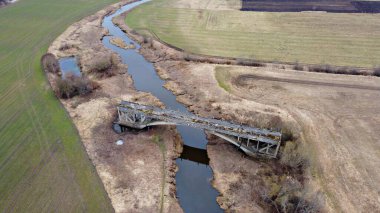 Abava Nehri üzerinde kuş bakışı yolu olmayan, tamamlanmamış eski bir köprü..