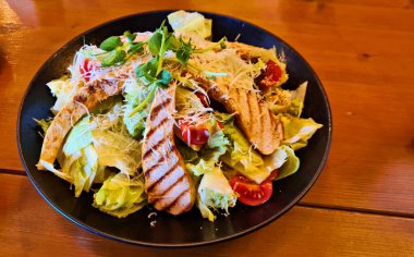 Tabakta taze salata ile ızgara beyaz et parçaları..