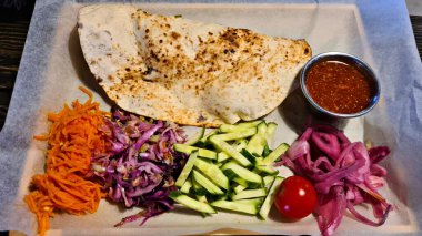 Öğle yemeği için taze sebze salatasıyla ızgara pirzola ve etli cheburek..