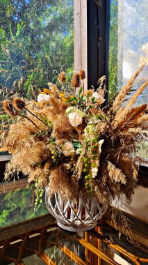 Vazodaki farklı kurumuş çiçeklerin bileşimi pencere tarafından verandaya monte edilir.