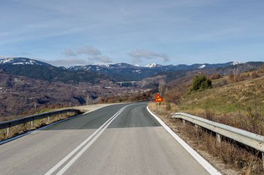 Güneşli bir kış gününde dağlarda manzaralı kırsal yol (Yunanistan)