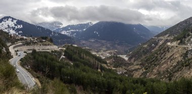 Kışın, bulutlu, sisli bir günde, büyük, karlı dağ ve yolların (Epirus bölgesi, Yunanistan) manzarası