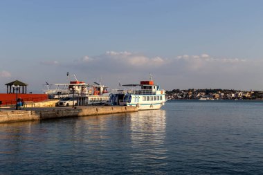 Yolcu gemileri denizin arka planına karşı iskeleye demirlemişti (Yunanistan, Salamis Adası)