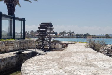 Karst bataklığı yakınlarındaki eski Yunan, tarihi su değirmeni (Yunanistan, Argostoli, Kefalonia) Yazın, güneşli günde.