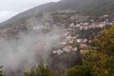 Bulutlu, soğuk ve kış günlerinde dağların, sislerin (Yunanistan, Epirus) güzel panoramik manzarası