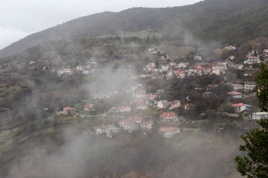Bulutlu, soğuk ve kış günlerinde dağların, sislerin (Yunanistan, Epirus) güzel panoramik manzarası