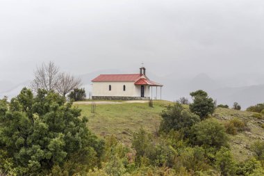 Dağlardaki küçük, Ortodoks, Hristiyan kilisesi bulutlu, sisli bir kış gününde