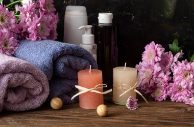Spa natürmort. Kişisel hijyen eşyaları, narin kasımpatılar çiçekler, kapalı masa havluları.