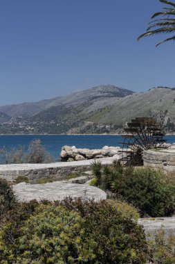 Karst bataklığı yakınlarındaki eski Yunan, tarihi su değirmeni (Yunanistan, Argostoli, Kefalonia) Yazın, güneşli günde.