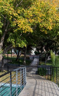 City of Athens, Greece. City landscape. Modern view of square (district Korydallos) with trees and flower beds on a sunny autumn day clipart