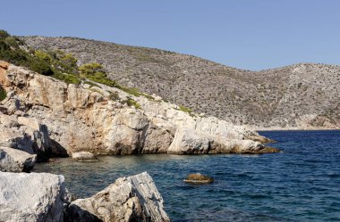 Deniz Burnu. Güneşli bir sonbahar gününde vahşi, kayalık bir sahil ve sakin bir deniz manzarası
