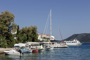 View of the promenade with yachts, vessel and shops on the island of Skopelos (Northern Sporades, Greece) on a sunny summer day