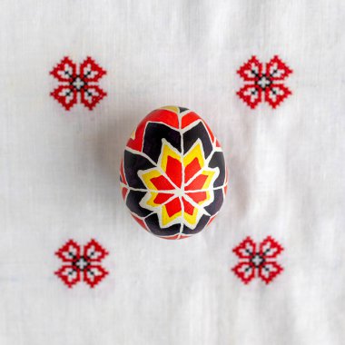 Nakışlı masa örtüsünde siyah ve kırmızı desenli Paskalya yumurtası. Paskalya arkaplanı, kartpostal