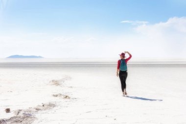 Şapkalı bir kız tuz gölünde yürür. Salar de Uyuni, Bolivya
