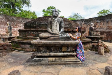 Kadın Sri Lanka 'daki antik bir tapınakta Buda heykelini ziyaret ediyor. Polonnaruwa