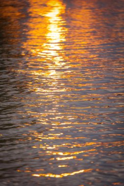 Su yüzeyinde Altın Gün Batımı Yansımaları