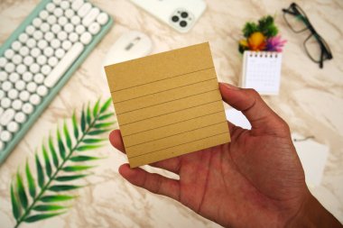 Beyaz mermer çalışma arka planına karşı erkek elinde kahverengi defter