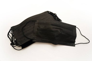 Siyah tek kullanımlık tıbbi maske beyaz arkaplanda izole edilmiş..