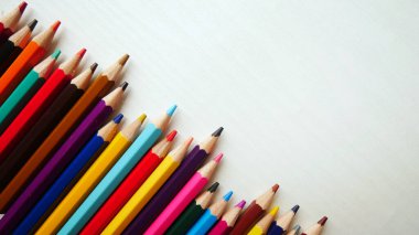 Beyaz mermer arka planda renkli kalem boyaları, renkli kalem kalemleriyle okula dönüş metni..