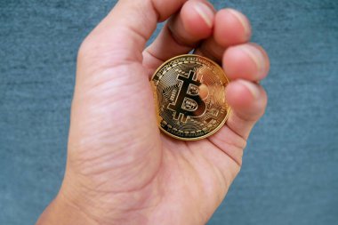 Kripto para birimi altın bitcoin. Bitcoin logolu bitcoin tutan adam. Elektronik sanal para.