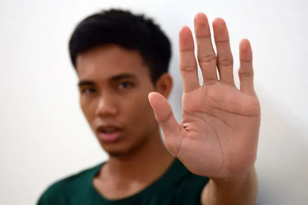 Man shows hand strength and palm forward with blurred body - concept of stop, strength, stop violence, five fingers on hand.