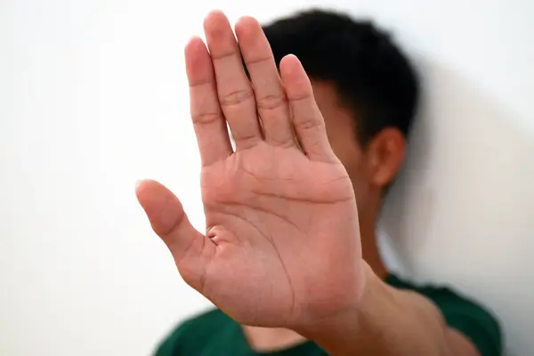 Man shows hand strength and palm forward with blurred body - concept of stop, strength, stop violence, five fingers on hand.