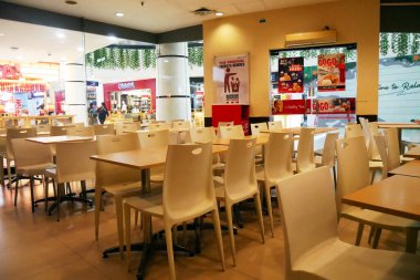 Boş beyaz sandalyeleri ve masaları olan modern bir kafe. Otel salonundaki lobi barının ikinci bölümde lüks bir tasarımı var.