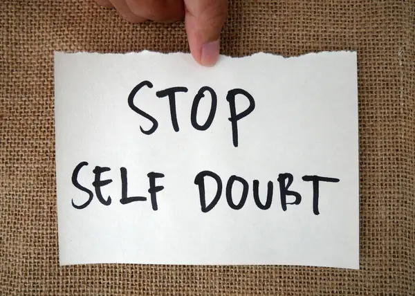 Handwritten message paper STOP SELF DOUBT, concept of self worth , stop striving for approval, more valid , more loved or validation , you are good enough