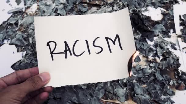 Mano Sosteniendo Papel Quemado Con Palabra Racismo — Vídeos de Stock