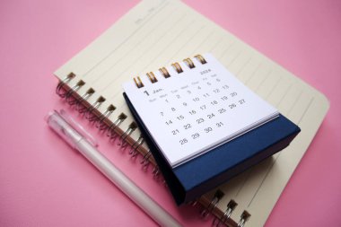 Hoş geldin 2024. 2024 Ocak 'ında masa takvimi pembe arka planda izole edildi. Portföyümde de benzer bir resim var..