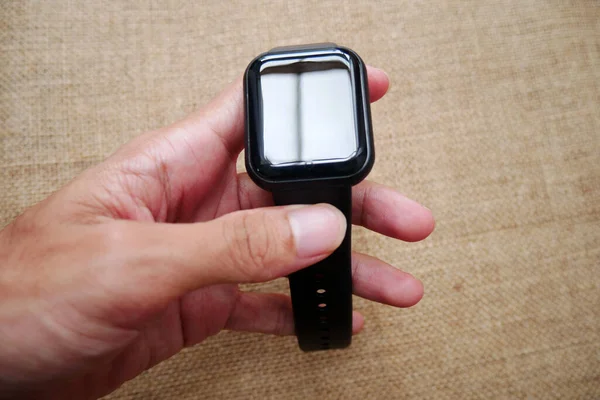 Smartwatch on wrist wearable technology on a burlap background
