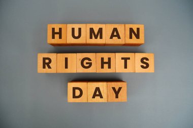 Gri arka planda izole edilmiş tahta küpte İnsan Hakları Günü.