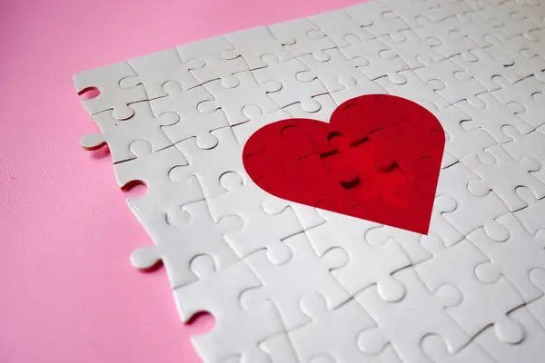 Jigsaw puzzle pieces in form of heart on a background. The concept of a complementary relationship, solving love problems together, charity, donation, helping concept. Perfect match, reunion.