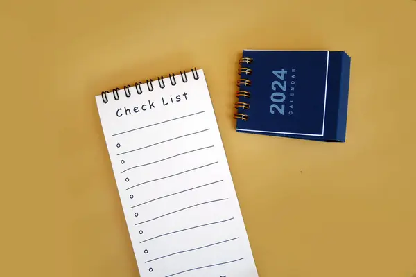 Checklist book with 2024 calendar. New Year 2024 goals, resolutions, plan, action, checklist concept. New Year\'s resolution plan. copy space.