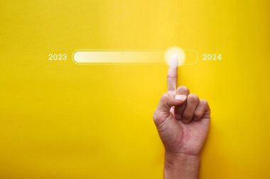 İş adamının eli 2023 'ten 2024' e değişmek için yıl sonu indirme durum çubuğuna dokunuyor. Teknoloji konsepti, yeni bir işe başlamak ve yeni bir hayata başlamak.