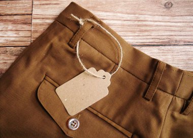 Ahşap arkaplan ile boş pantolon malzeme etiketi.