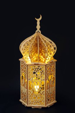 Koyu arkaplanda İslami oymalar olan altın parlayan ahşap Ramazan feneri. Mutlu Ramazanlar. Önemli İslami bayramlar. Afiş fotoğrafı veya İslami bayram tebrik kartı.