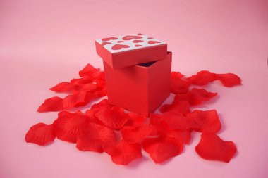 Sevgililer Günü hediye kutusu. Sevgililer Günü afişi tasarımın kutlu olsun. Pembe arka planda hediyeler ve güller var. Boşluğu kopyala.