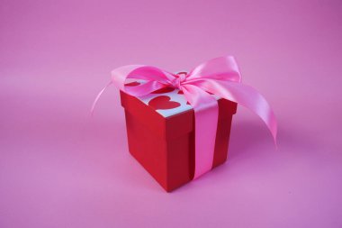 Sevgililer Günü hediye kutusu. Sevgililer Günü afişi tasarımın kutlu olsun. Pembe arka planda hediyeler ve güller var. Boşluğu kopyala.