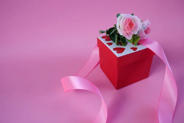 Valentine\'s day gift box. Happy valentines day banner design with present box and roses on pink background. Copy space.